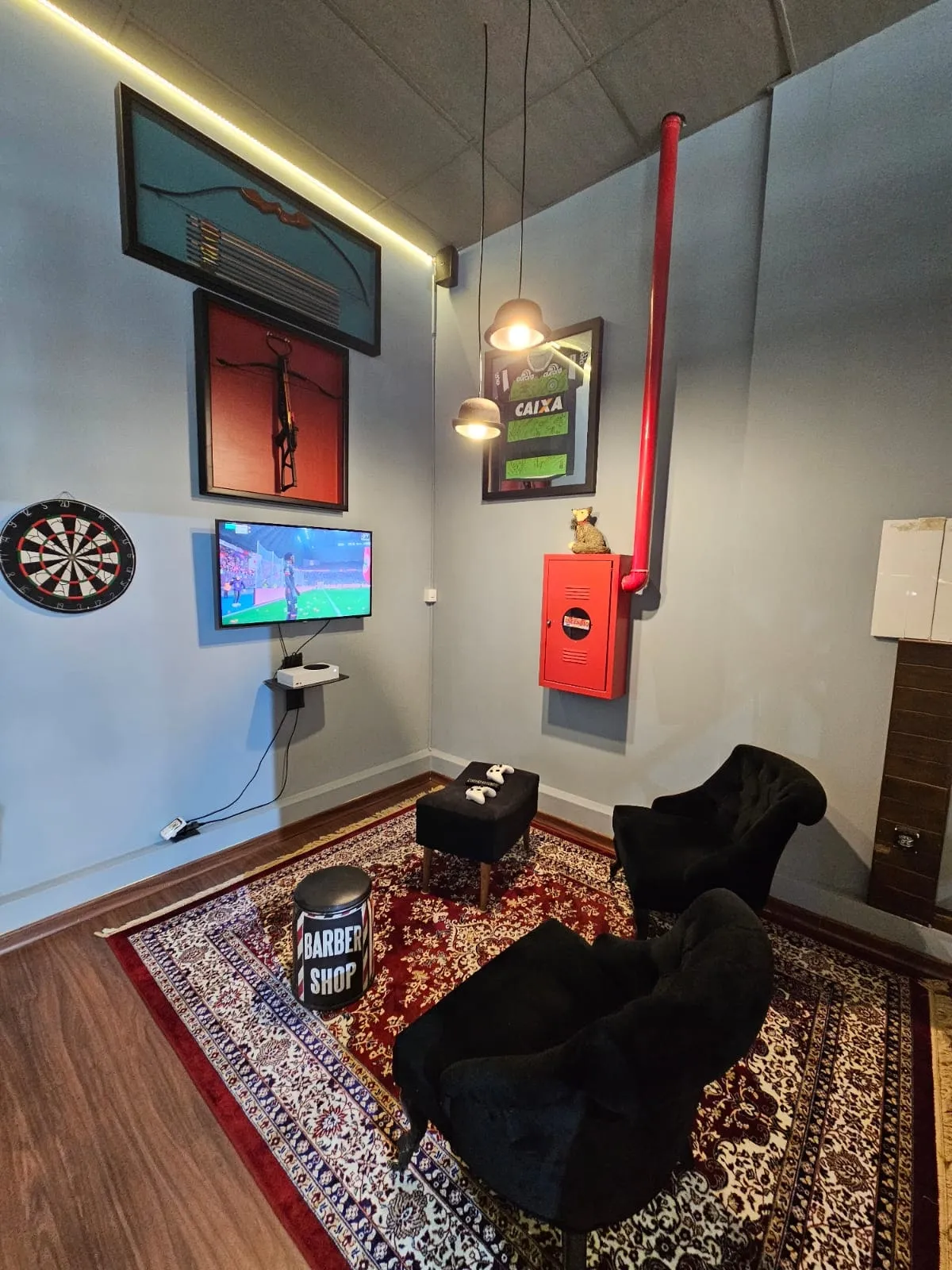 Lounge com poltronas, alvo de dardos e TV